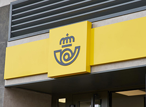 Logotipo CORREOS en exterior de oficina.