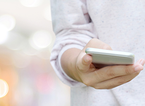 Detalle de la mano de una mujer con un teléfono móvil.
