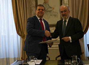 El presidente de CORREOS, Juan Manuel Serrano, y el director de la RAE y vicepresidente de la Fundación pro-RAE, Santiago Muñoz, se dan la mano tras