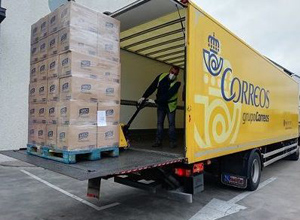 Descarga de palés de alimentos de un camión de CORREOS.