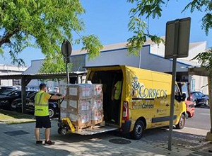 Descarga de cajas con mascarillas de una furgoneta de CORREOS.