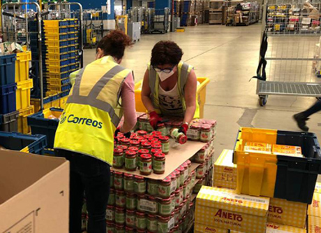 Voluntarias de CORREOS preparan el reparto de alimentos para familias desfavorecidas.