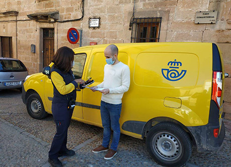 Cartera rural atendiendo a un cliente.