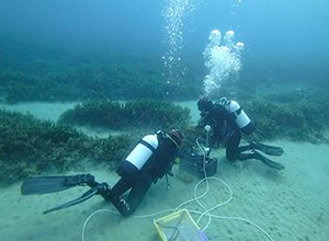 Dos buzos trabajando en el fondo del mar.